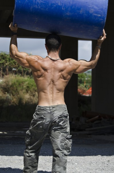 Back Of Muscular Construction Worker Shirtless In Building Site