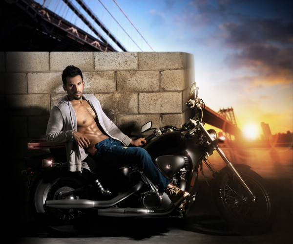 Sexy young fit male model on motorcycle outdoors at dawn